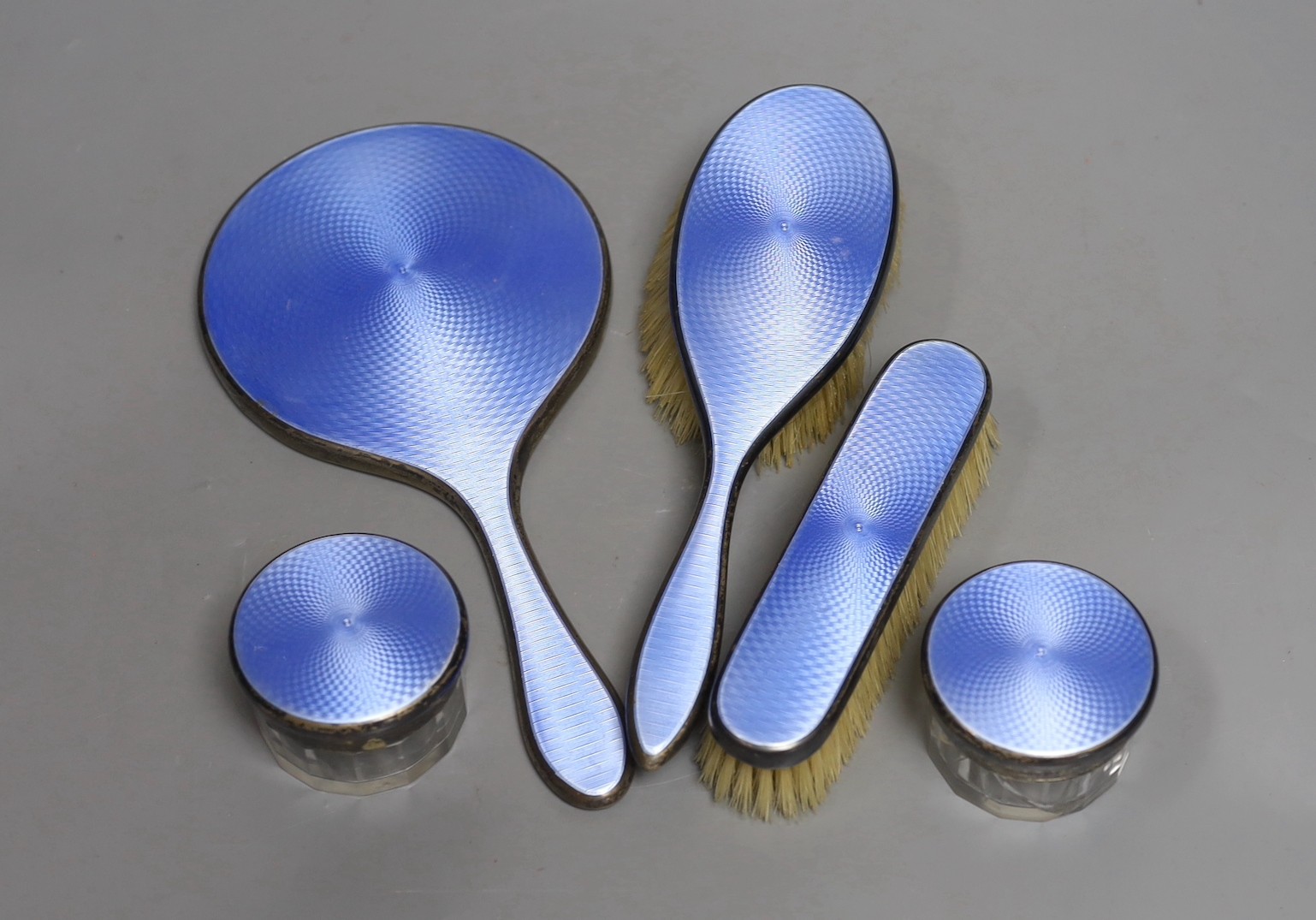 A George V blue enamelled silver five piece dressing table set, London, 1929.